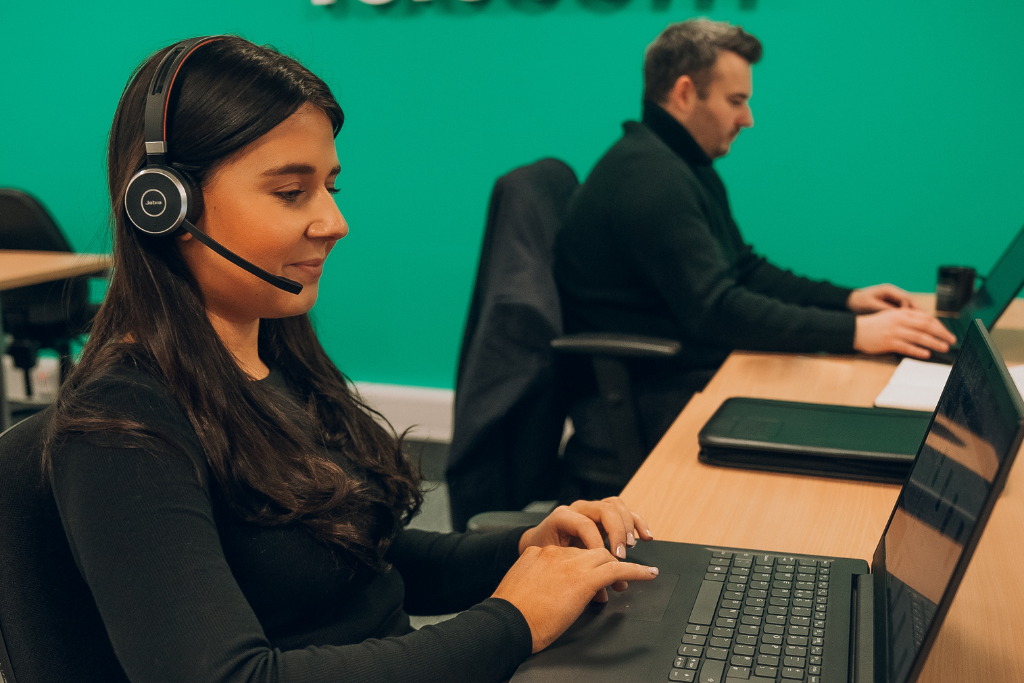Image shows an Account Manager talking to a client on her headset.