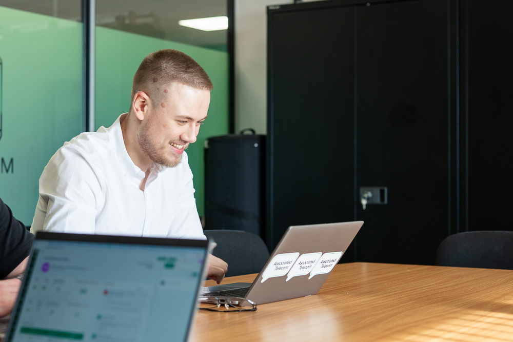Business professional using a laptop during a work meeting.