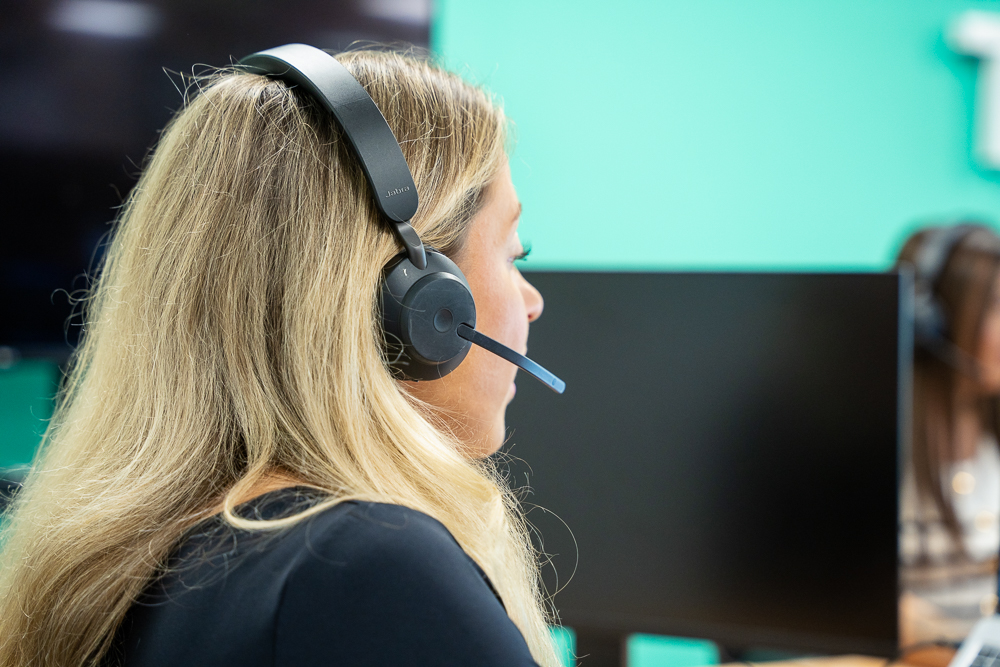 Associated Telecom office staff member wearing a headset.