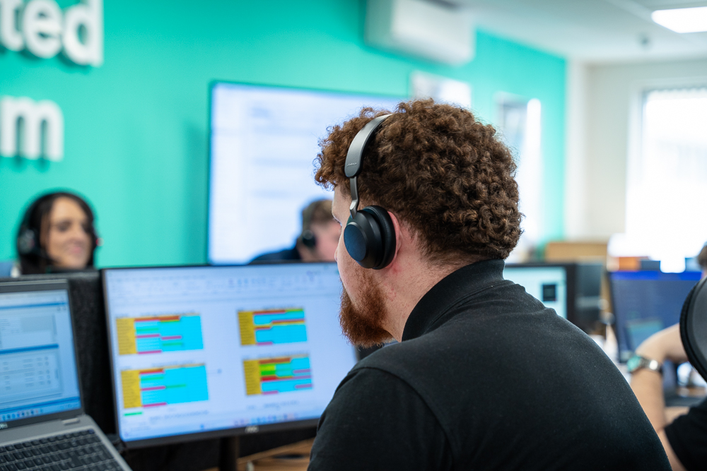 Associated Telecom office worker monitoring screens from a workstation.