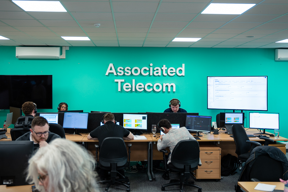 Customer support team working in an office with associated telecom branding.