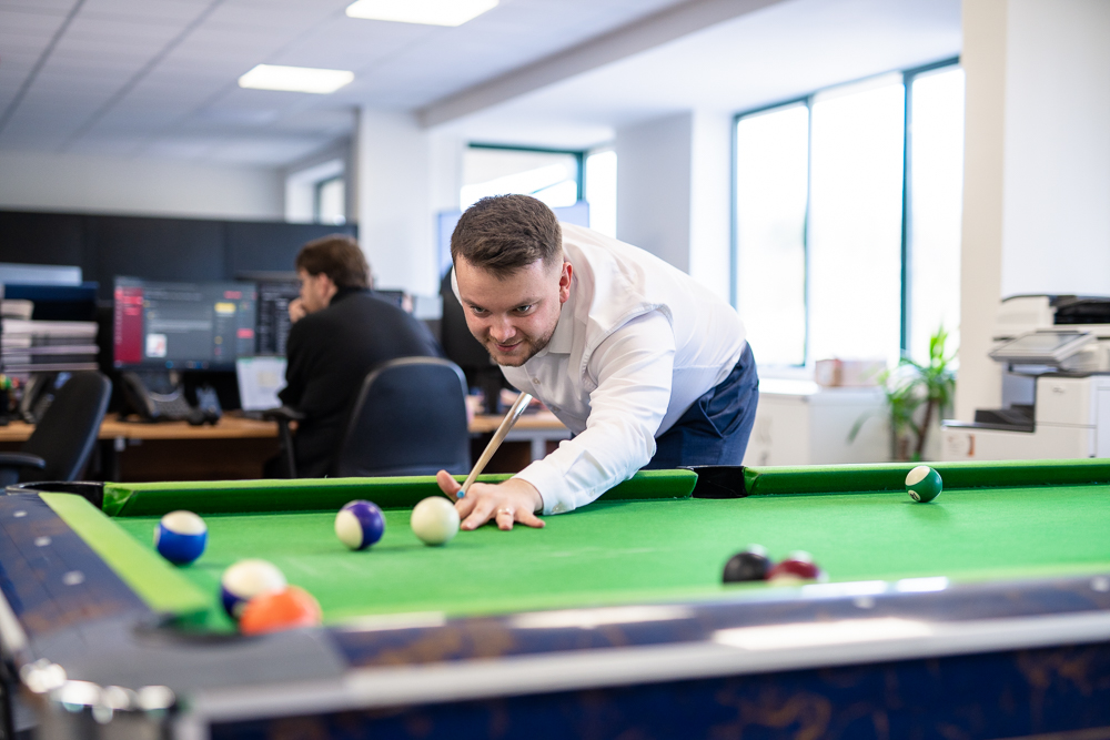 Office staff playing pool during a break.