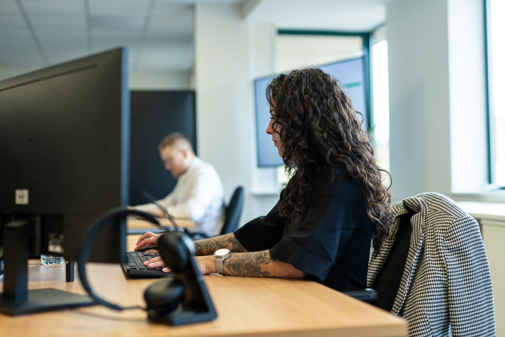 Associated Telecom employee working at a computer in the office.