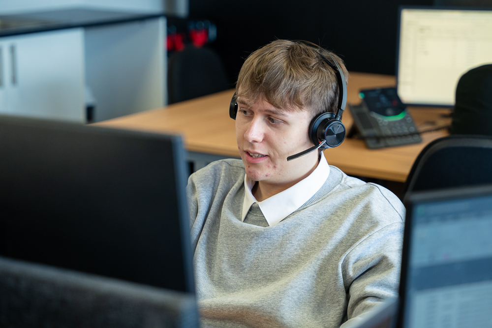 Telecom support agent wearing a headset in an office.