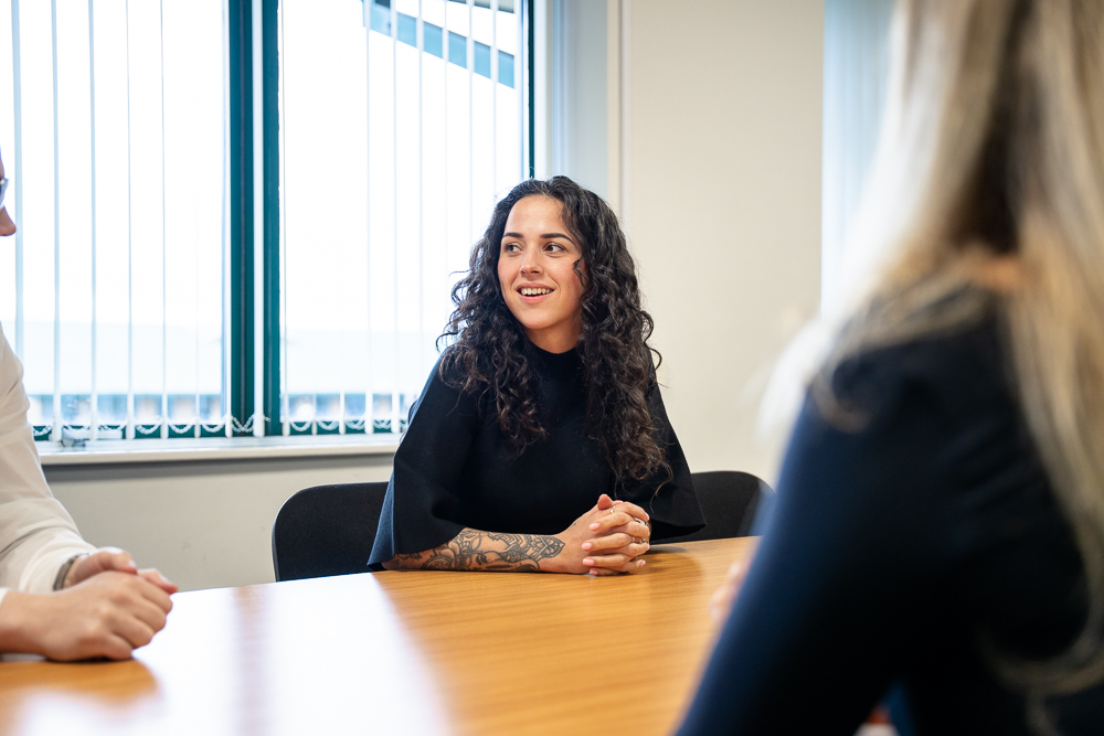 Business meeting in an office with a client speaking to staff.