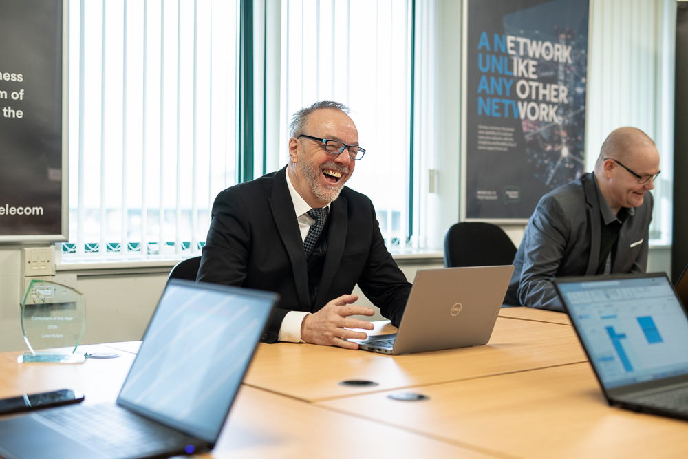 Associated Telecom senior business professional working at a laptop.