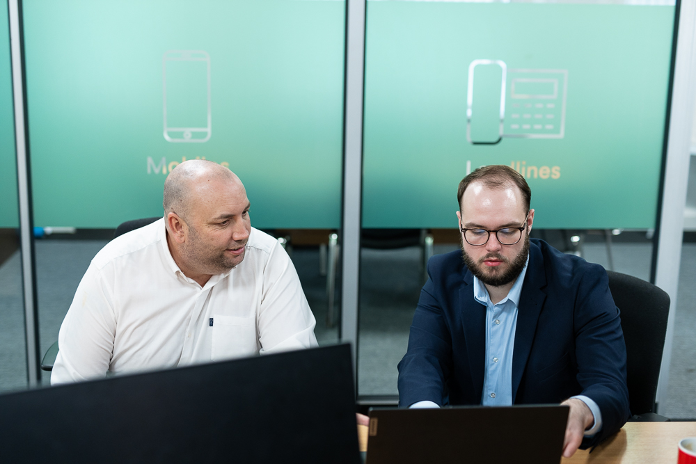 Associated Telecom team collaboration in a modern office environment.