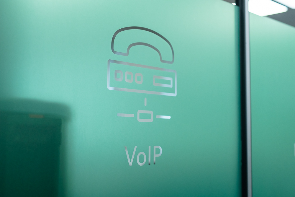 Associated Telecom branded office door with frosted glass VoIP logo.