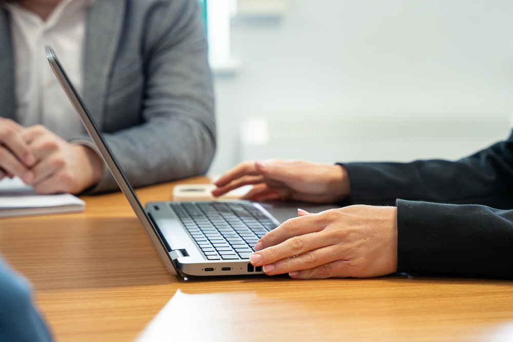 Associated Telecom employee typing on a laptop in the office.